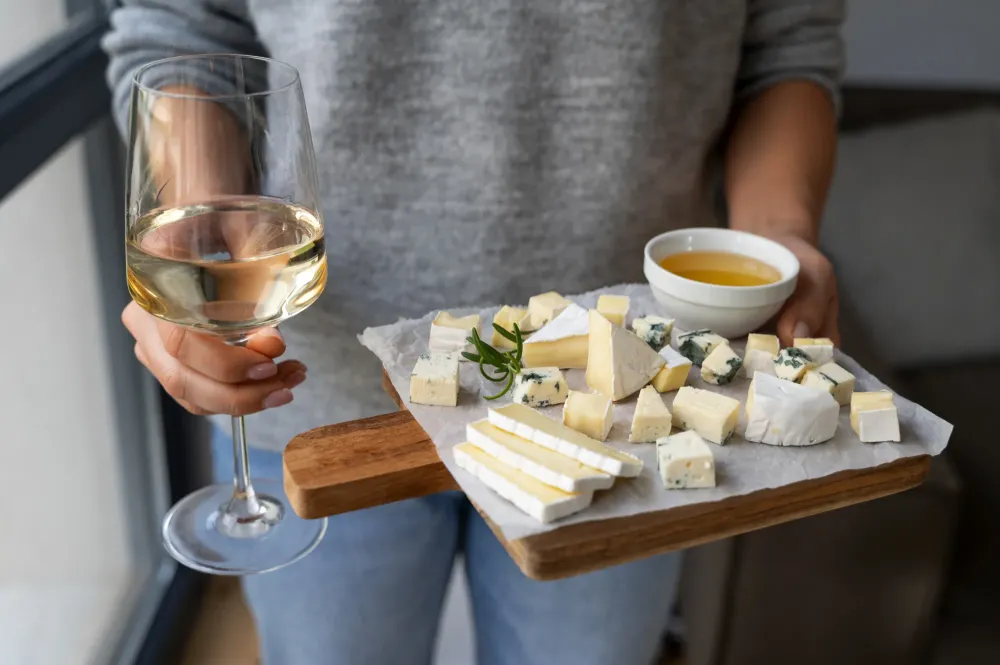 femme_vue_face_tient_plateau_fromage_verre_vin_blanc